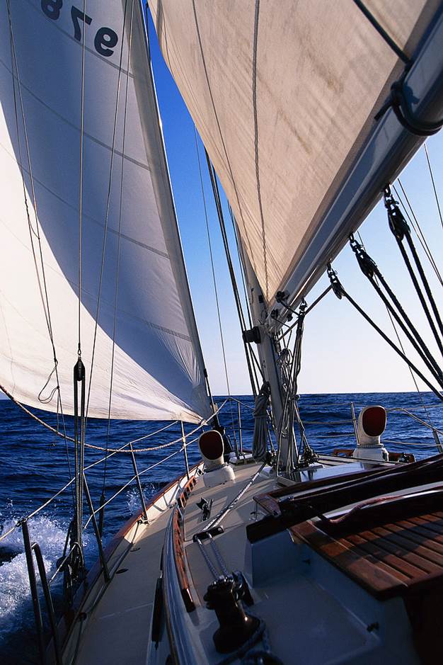 A sailing ship moving forward into a blue horizon