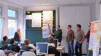 The team around Prof. Badri. Höher gathered in front of a presentation board to tell students about their achievements and goals, during the ninth interdisciplinary weeks.