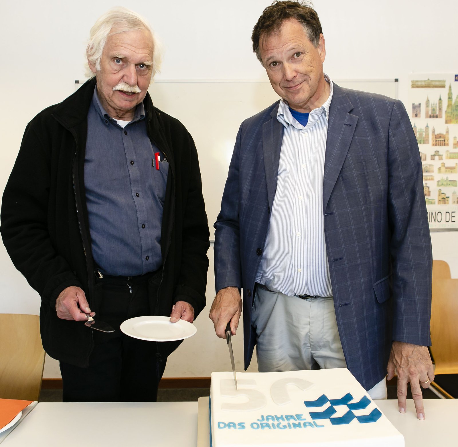 Eine Torte zum Fest durfte natürlich nicht fehlen: Prof. Dr. Udo Beer (r.) und Prof. Dr. Jürgen Spieckhoff schnitten sie im Alumni-Café an. Foto: Molter