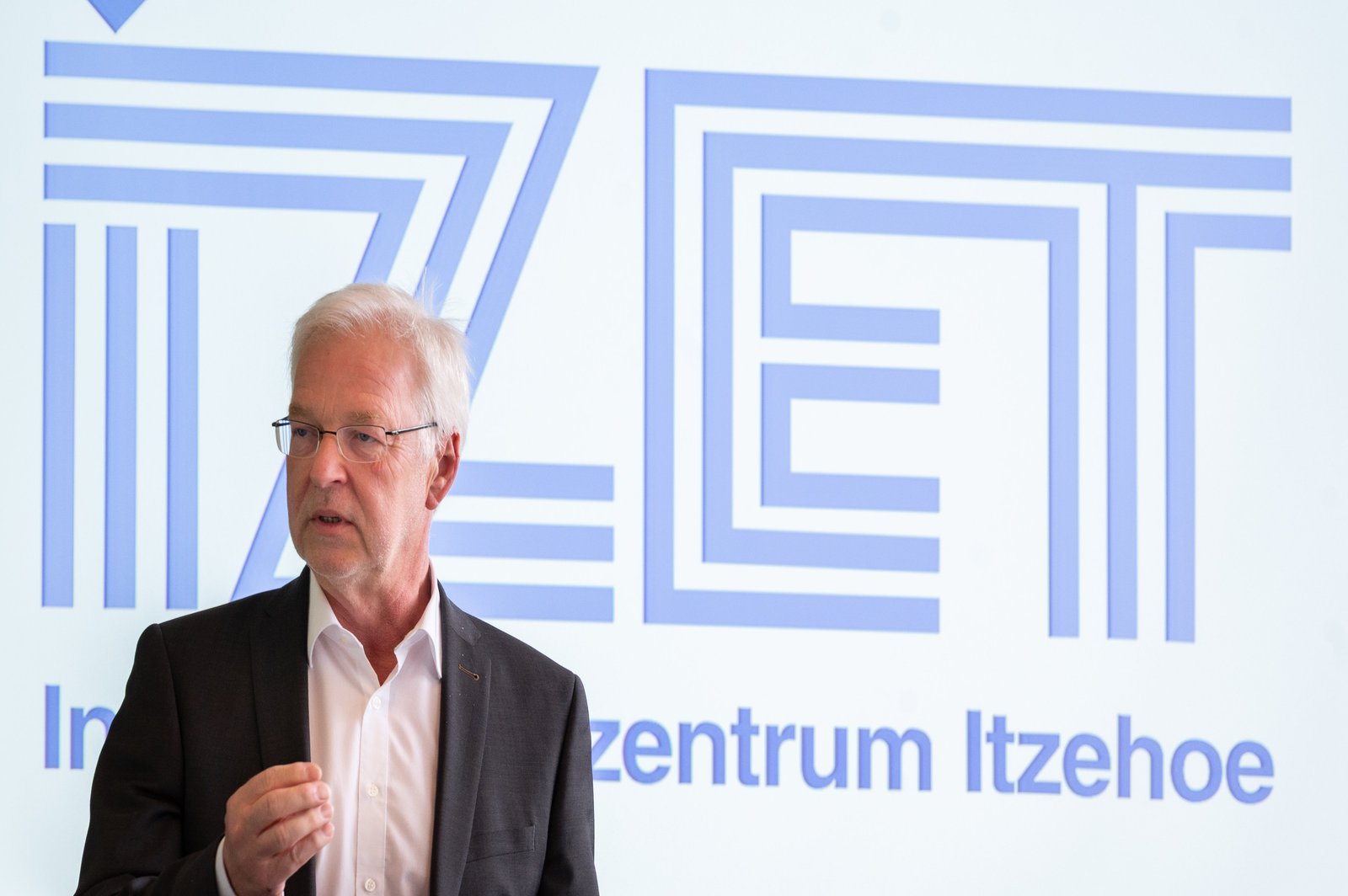 IZET-Geschäftsführer Prof. Dr. Ralf Thiericke im Portrait vor einer Präsentation