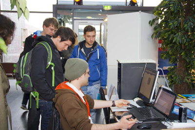 Eine Gruppe Studierender, schaut gespannt auf einen Rechner.