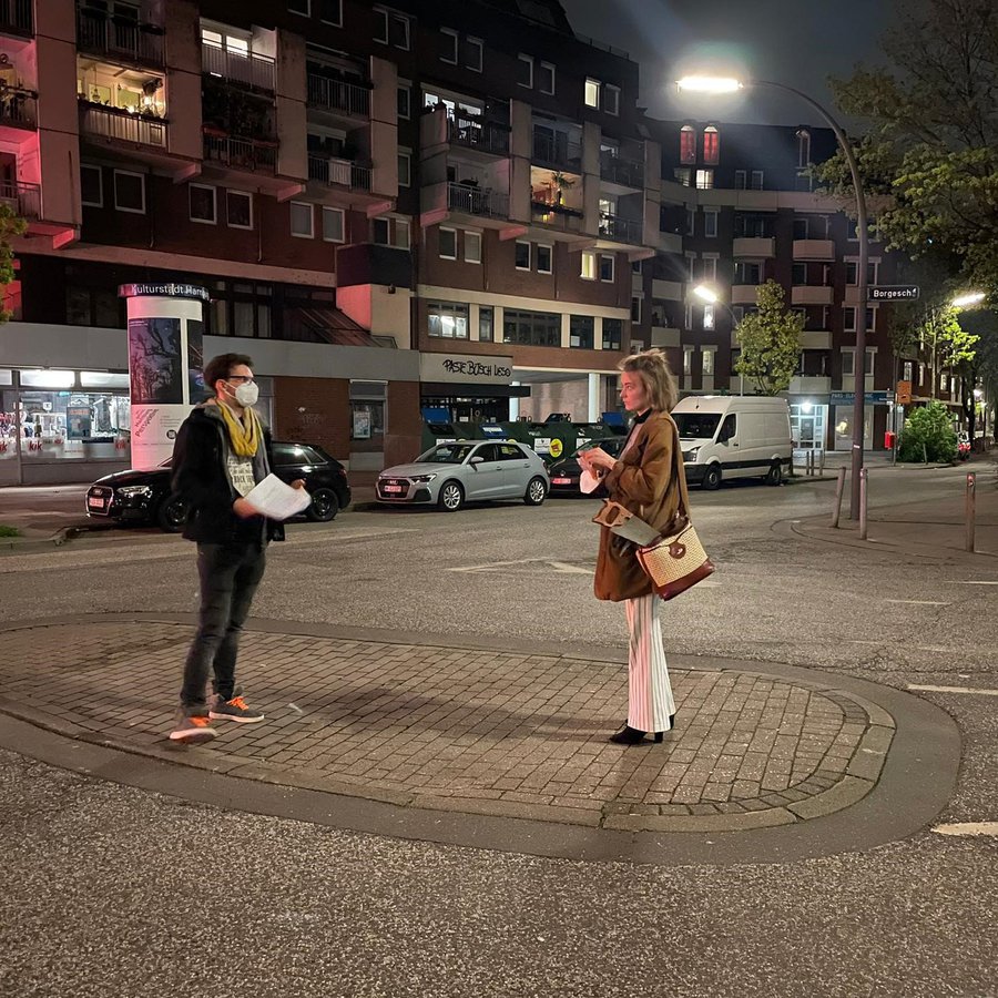 Regisseur Patrick Knittler und Schauspielerin Hannah Dalmeyer stehen in der Nacht auf einer Verkehrsinsel in Hamburg.