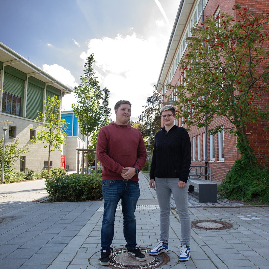 zwei Studierende stehen auf dem Campus der FH Kiel in Dietrichsdorf