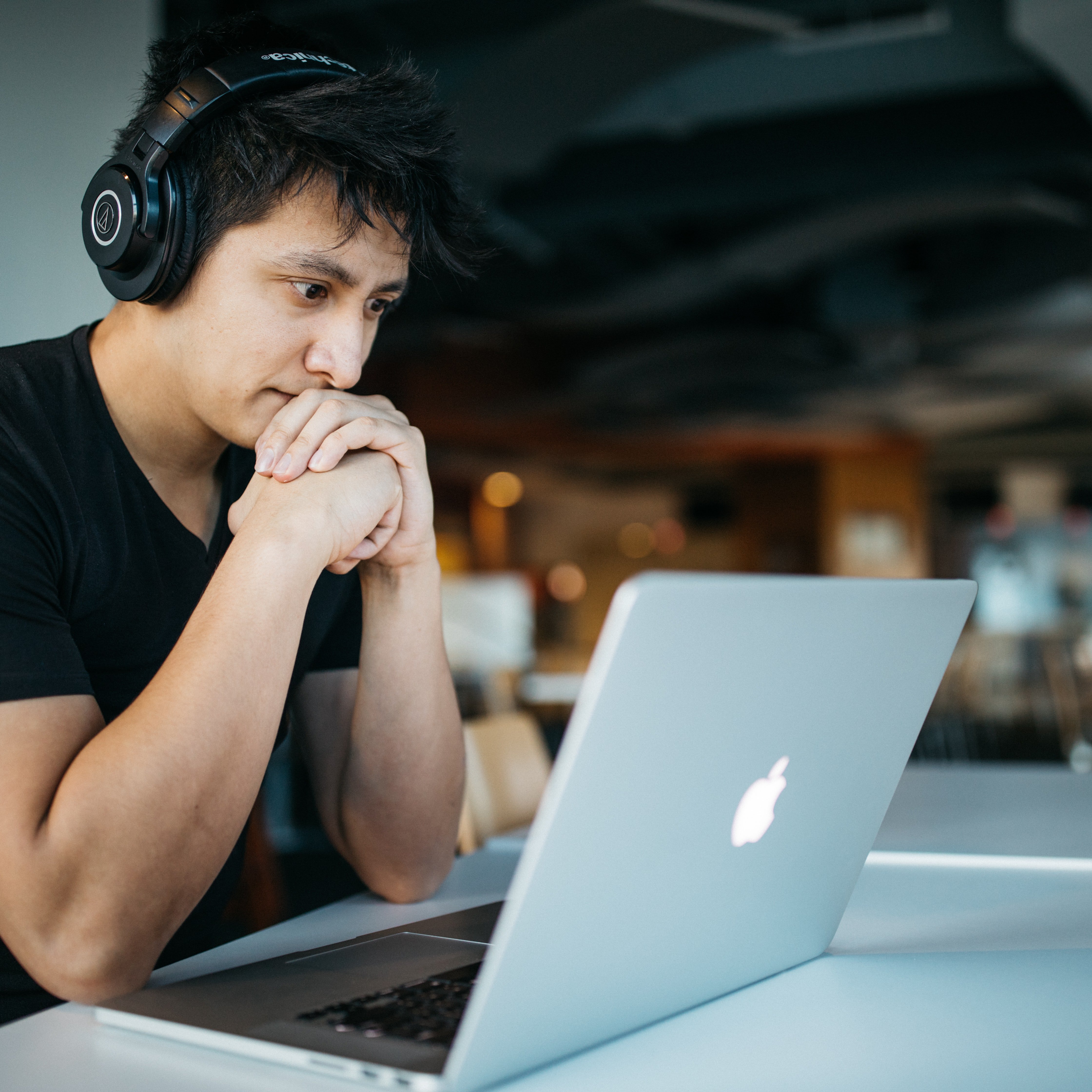 Ein Mann sitzt vor seinem Laptop, in grüblerischer Pose.