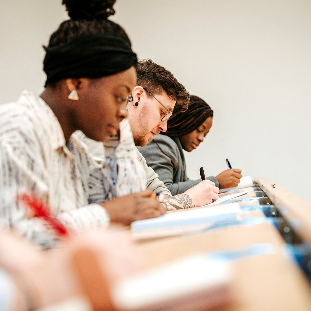 [Translate to English:] Studierende der Fachhochschule Kiel machen Notizen im Hörsaal