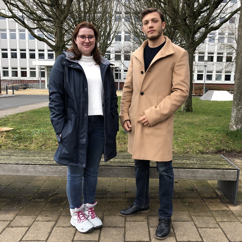 Eine junge Frau, Adriana Balasa, und ein junger Mann,  Alejandro Castellanos, stehen auf dem Campus der FH Kiel.