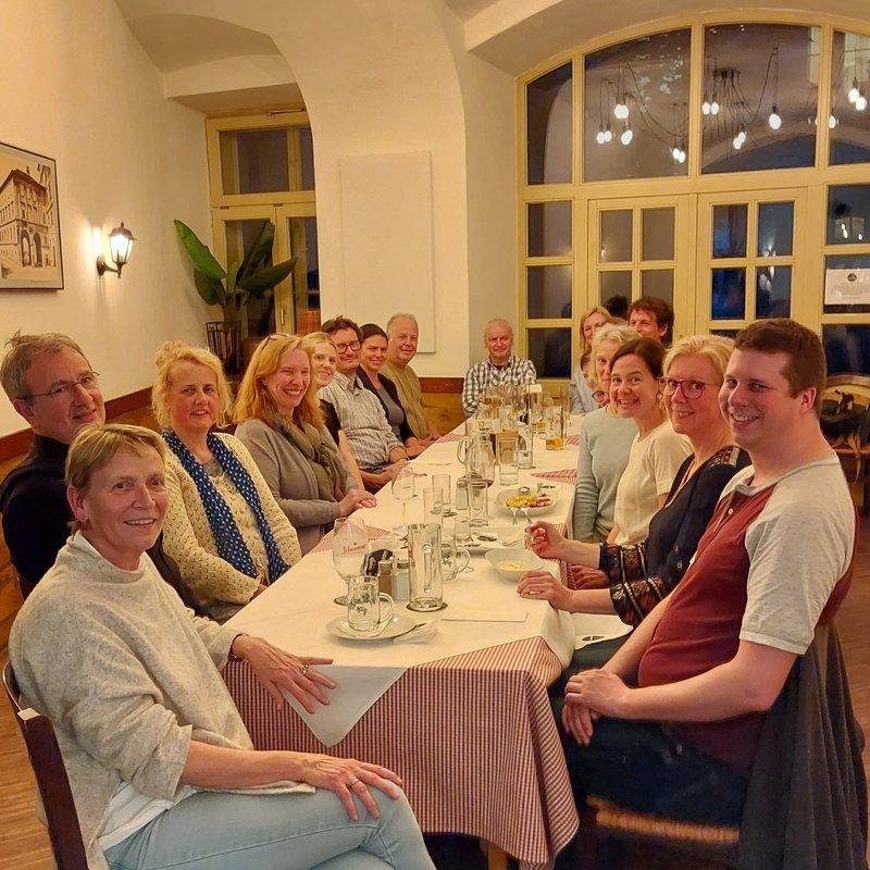 Eine Gruppe Menschen sitzt um einen Restaurantisch herum