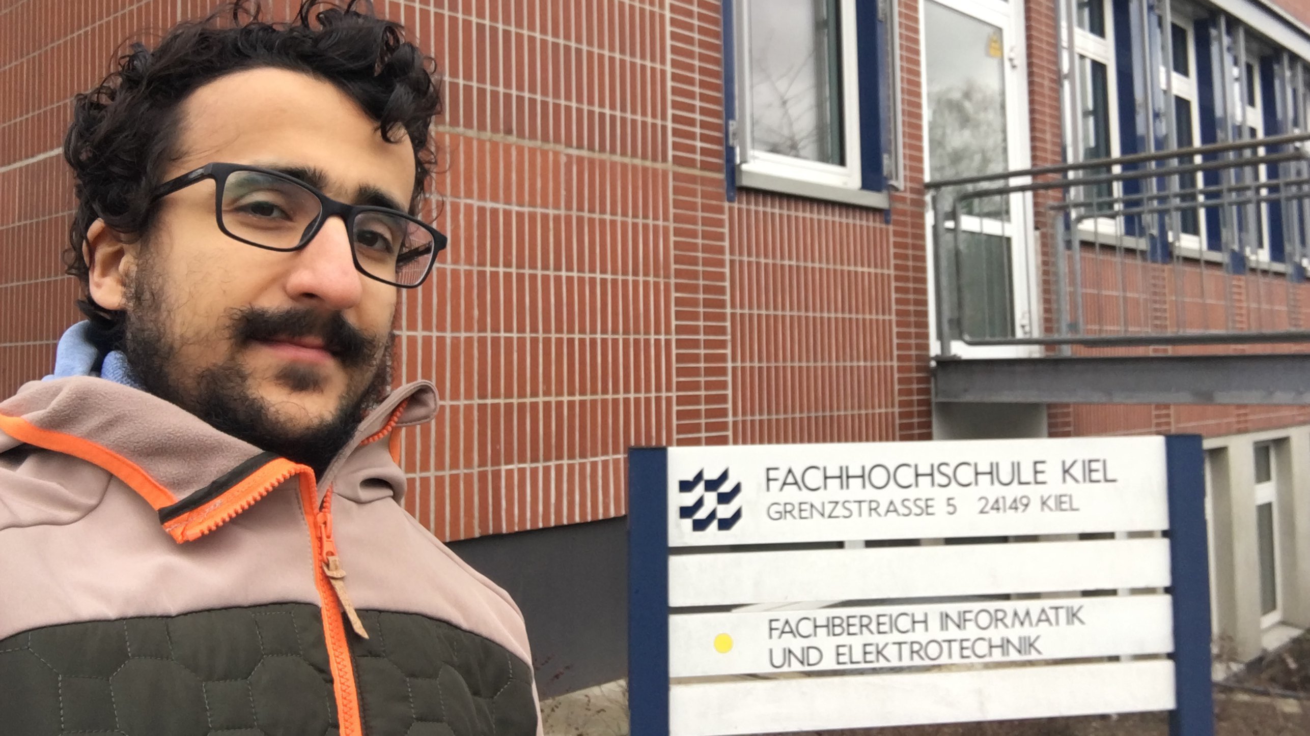 Erasmus-Student Eliass Kaddouri vor Schild Fachbereich Informatik und Elektrotechnik