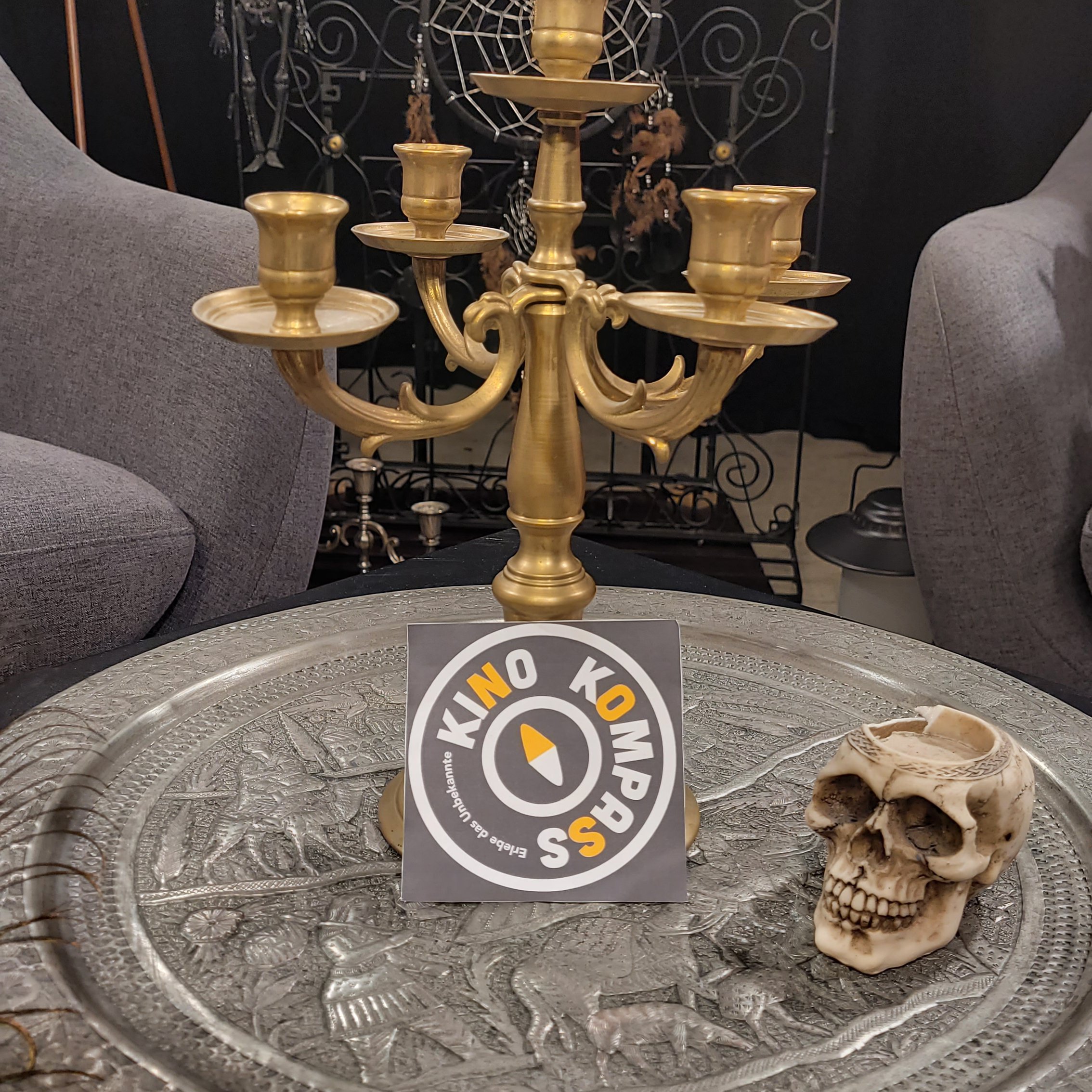 Ein Kerzenhalte und ein Totenschädel auf einem Tisch