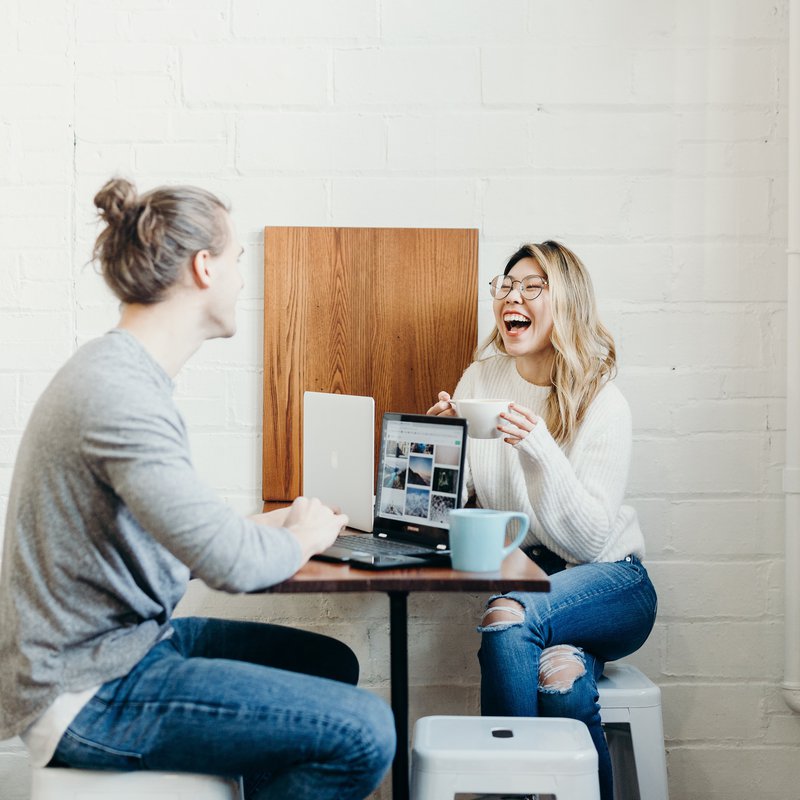 Zwei Frauen am Tisch mit Laptop und Kaffeetassen