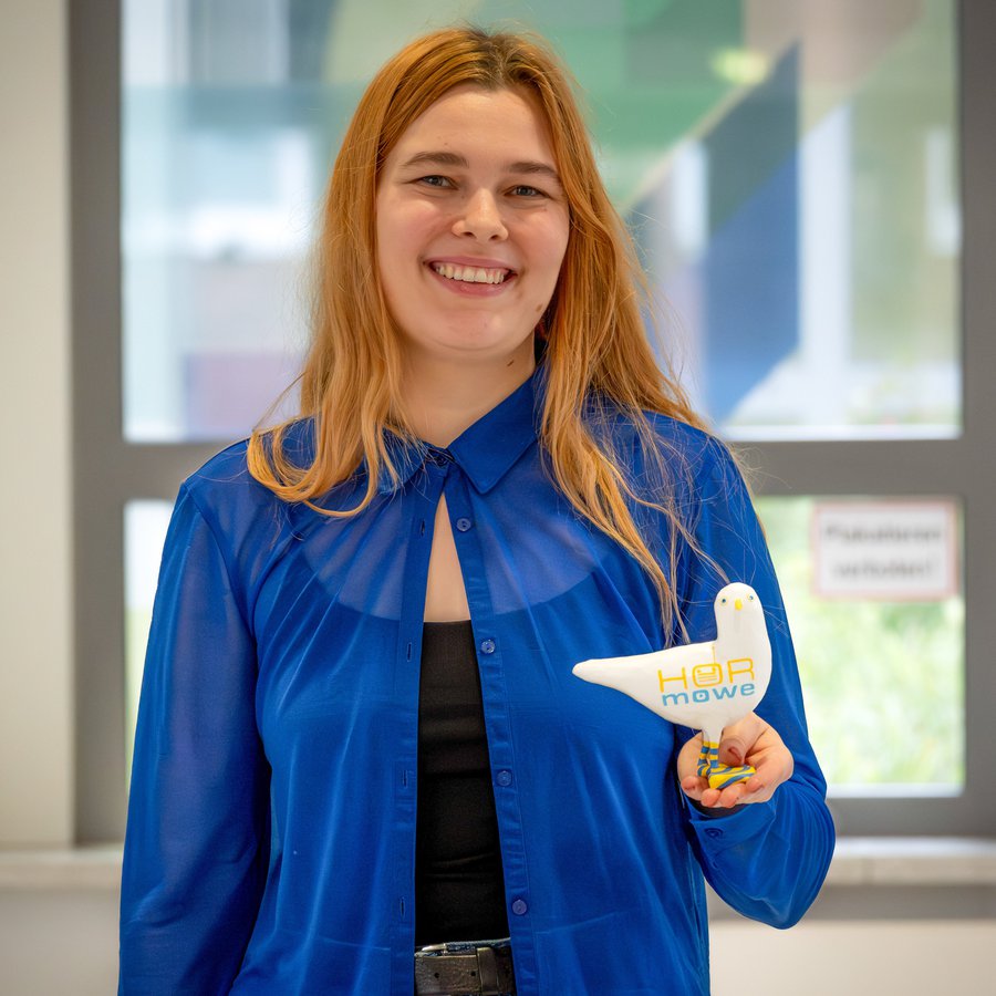 Portrait von Naomi Leutzow. Sie hält ihre Auszeichnung in den Händen. 