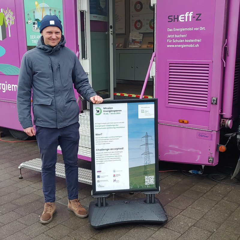 Ein lächelnder Mann vor einem Info-Truck