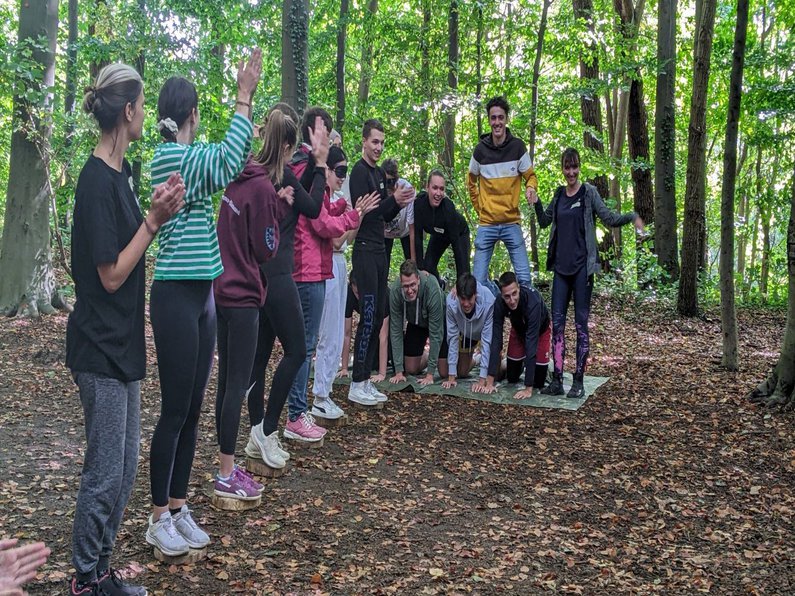 eine Gruppe Menschen im Wald macht Spiele