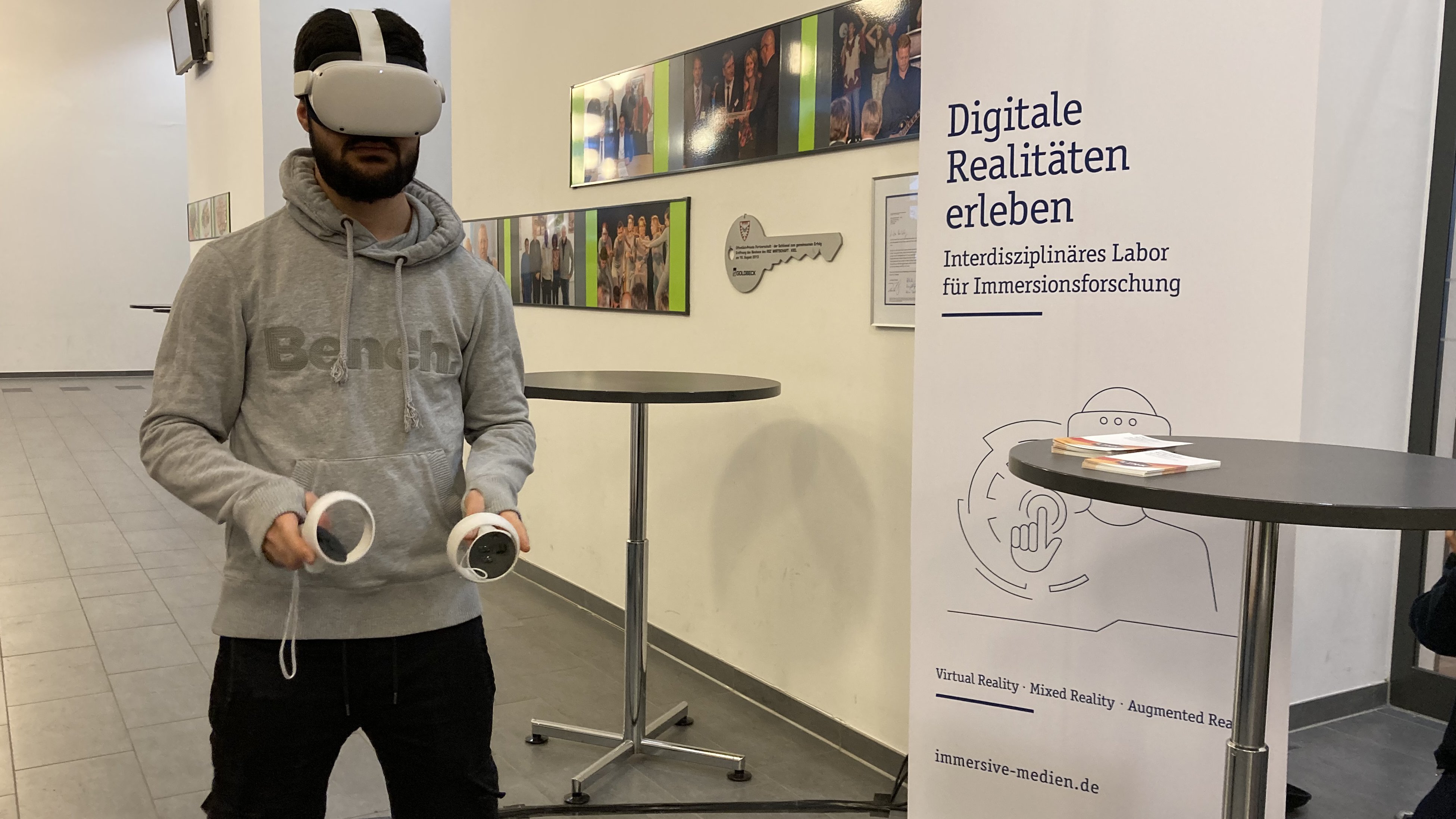 Ein Schüler trägt eine VR-Brille und zwei Controller