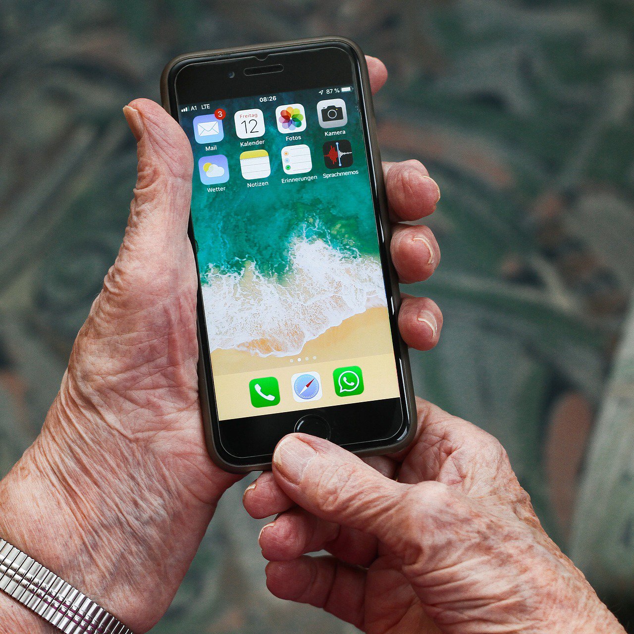 Seniorenhand mit Smartphone