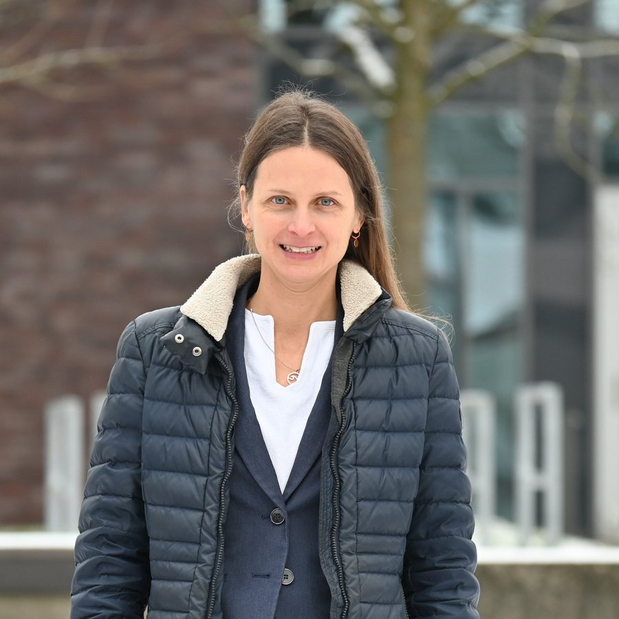 Portraitaufnahme von Cona Ehresmann vor dem Mehrzweckgebäude der FH Kiel  