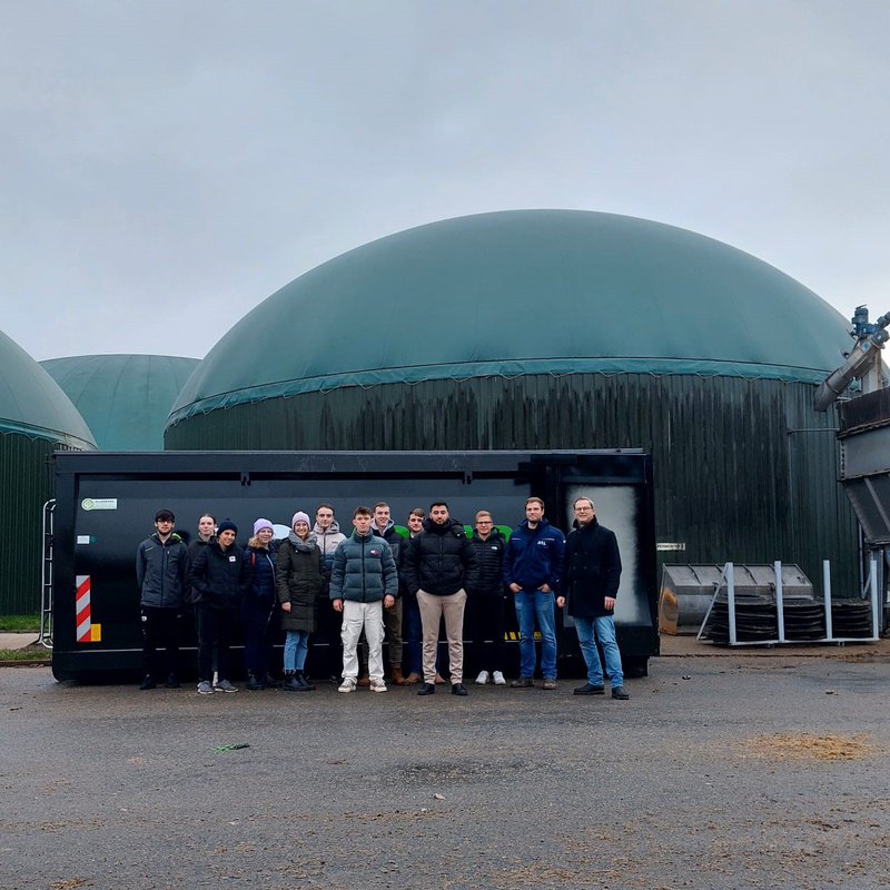 eine Gruppe Studierender der FH Kiel auf dem Gelände des Biogasbetriebs Lass in Tüttendorf bei Gettorf