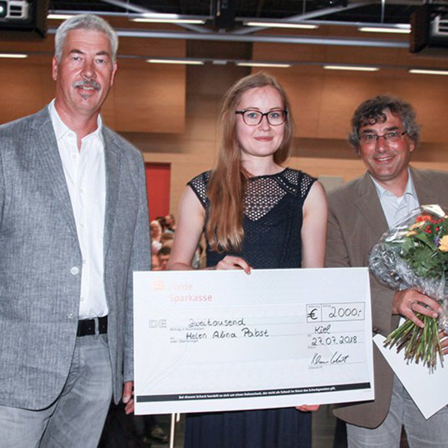 Prof. Dr.-Ing. Sven Olaf Neumann, Helen Alina Pabst den Preis haltend und FH-Vizepräsident Prof. Dr.-Ing. Klaus Lebert mit einem Blumenstrauß 