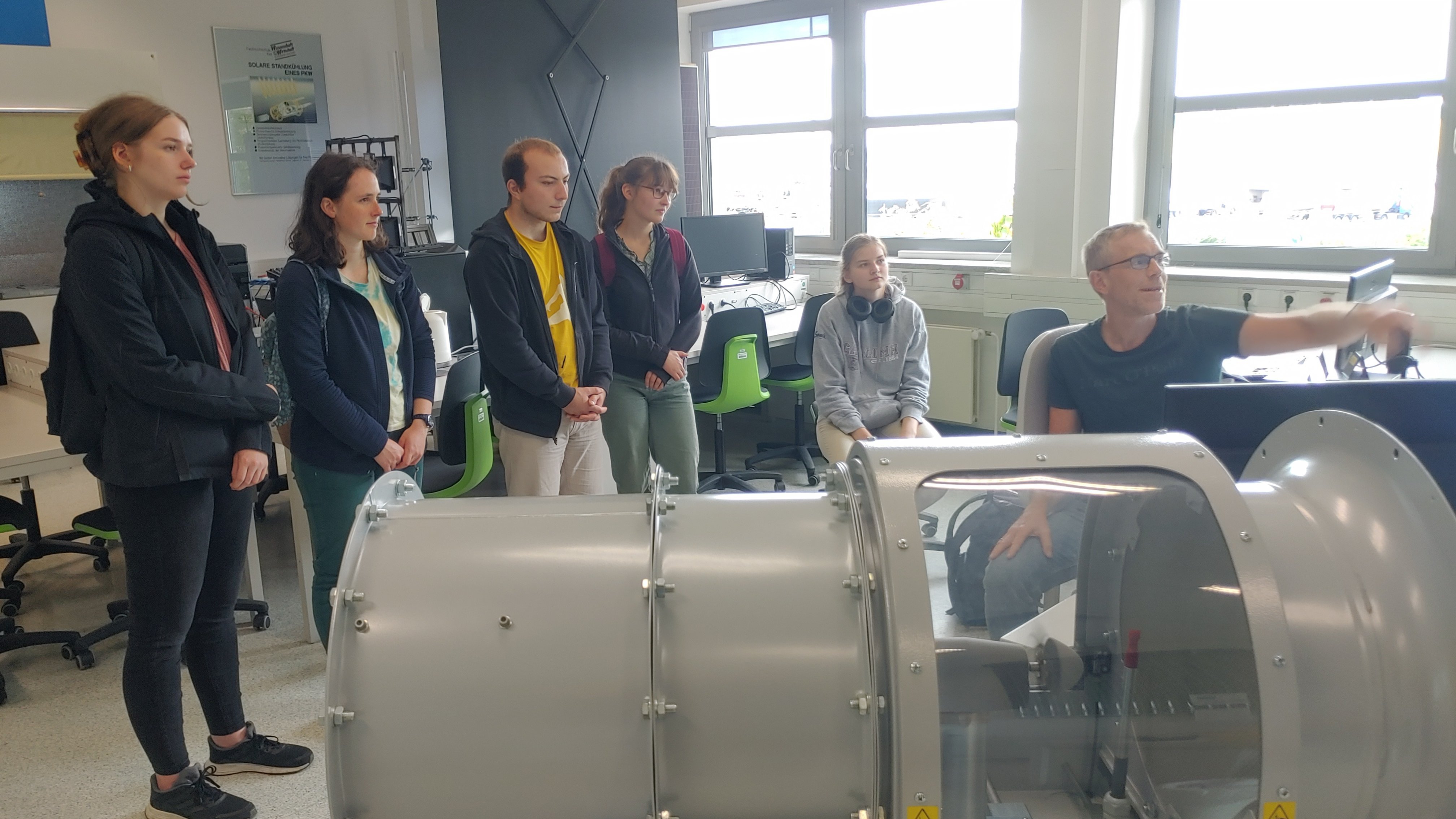 Prof. Andreas Luczak erklärt Besucherinnen und Besuchern des Science Day am Modell, wie Windkraftanlagen funktionieren