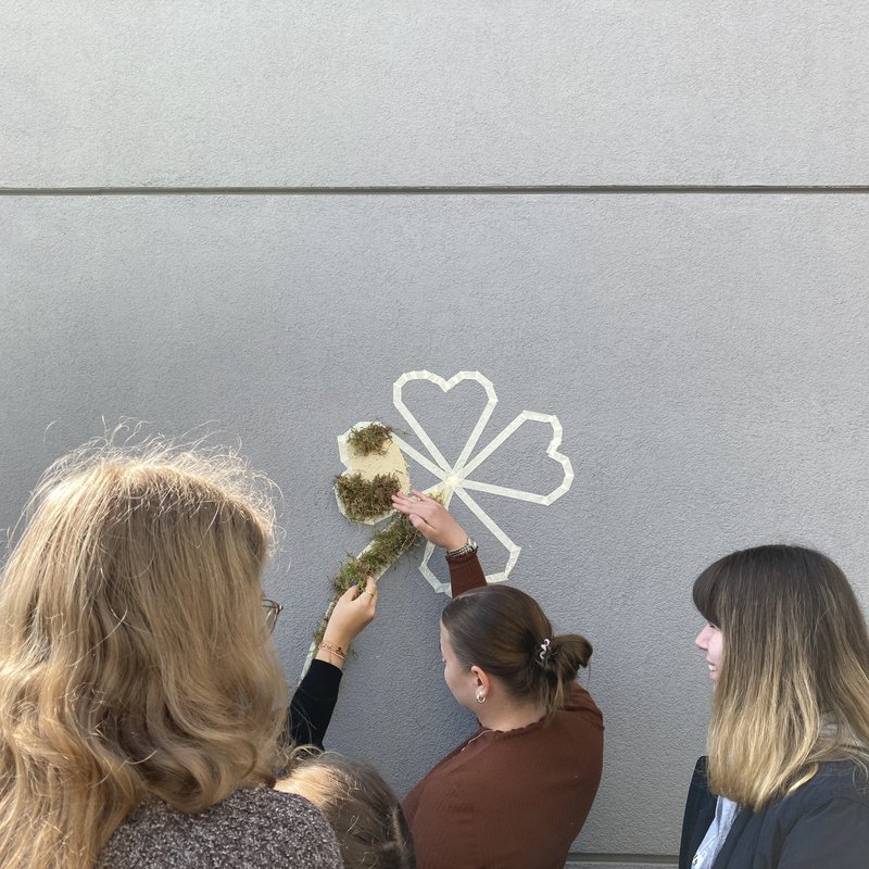 Schülerinnen und Studierende gestalten gemeinsam ein Moosgraffiti