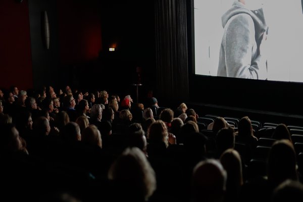 Ein Kino, in dem das Publikum aufmerksam auf die Leinwand achtet.