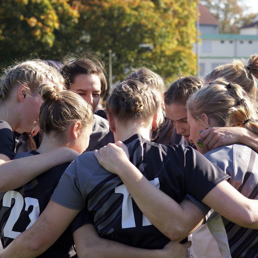 Gruppe von Frauen steckt Köpfe zusammen