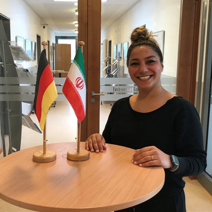 die neue Mitarbeiterin Soroor Saki an einem Stehtisch vor dem International Office der FH Kiel 