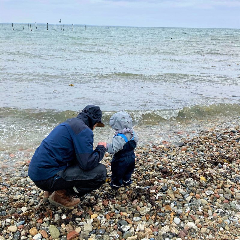 Vater mit Kind am Strand.