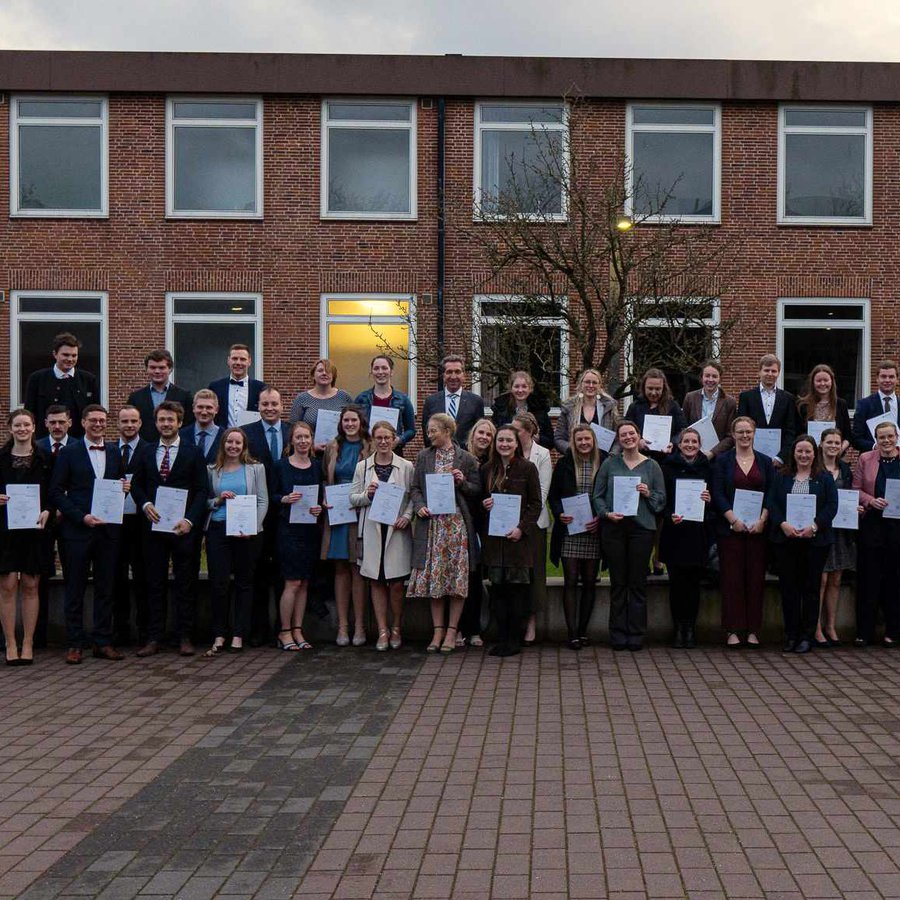 ein Gruppenfoto - viele Menschen stehen vor einem Gebäude