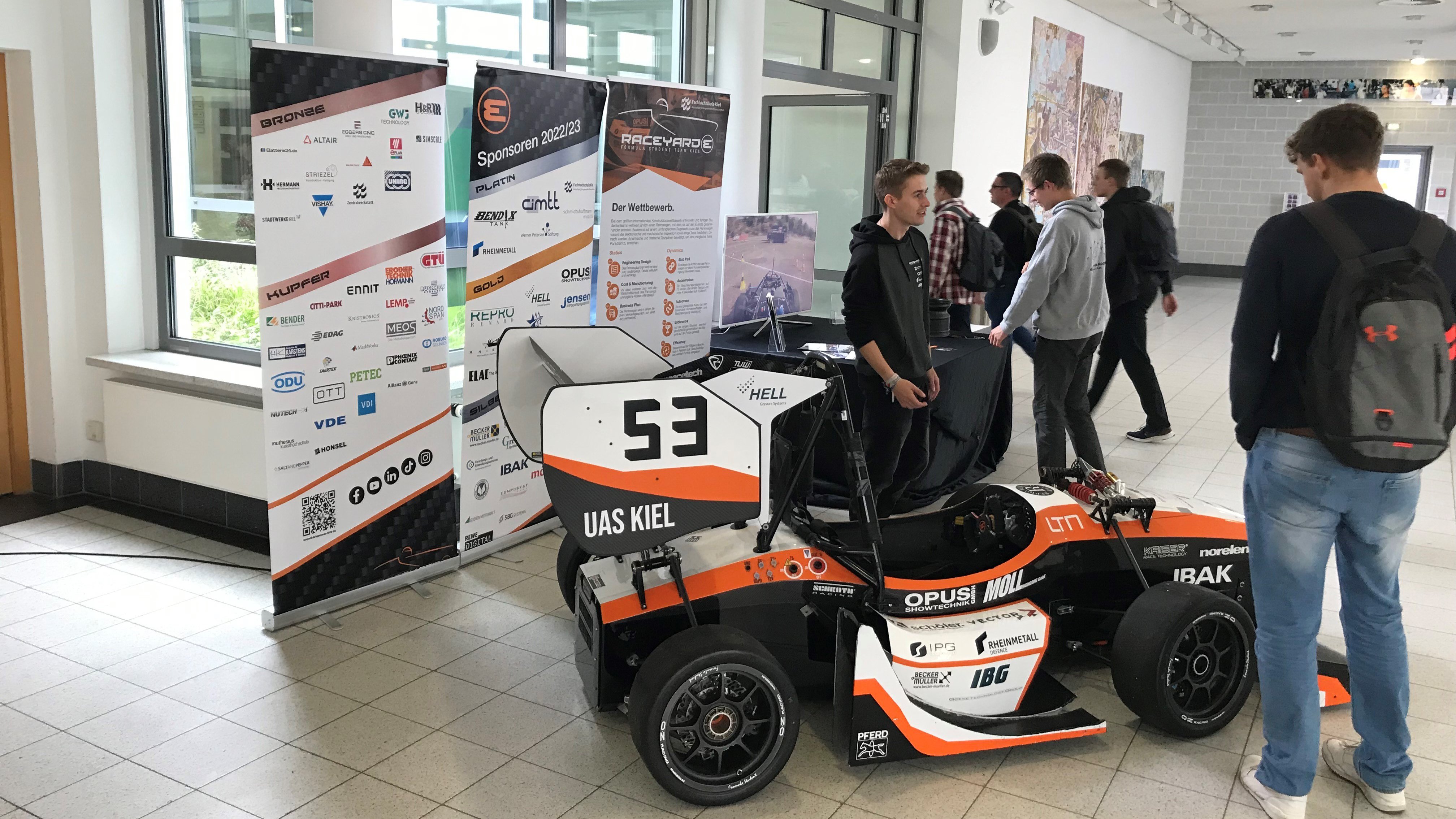 ein Rennwagen des Formula Student Teams Raceyard beim Science Day an der FH Kiel, drumherum stehen Studierende