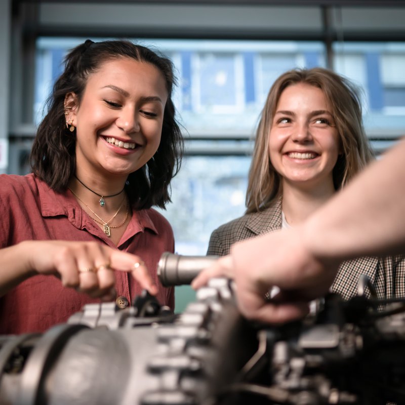 Zwei junge Frauen schauen sich einen Motorblock an. Foto: Patrick Knittler. 