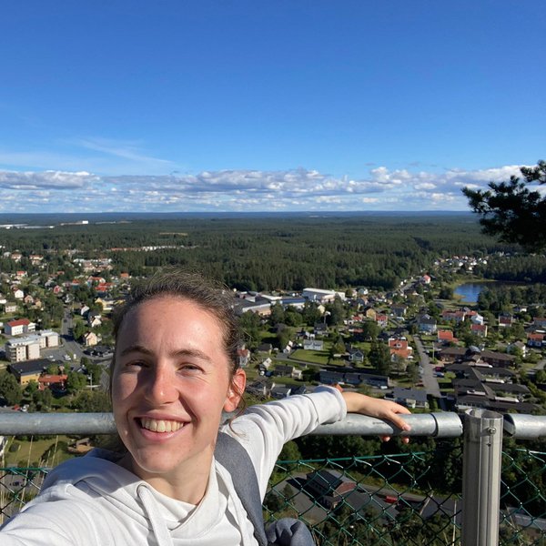 eine Frau lächelt vor schwedischer Kulisse in die Kamera