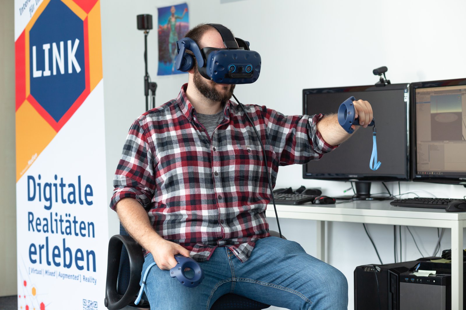 Ein Mann sitzt auf einem Stuhl und trägt eine VR-Brille