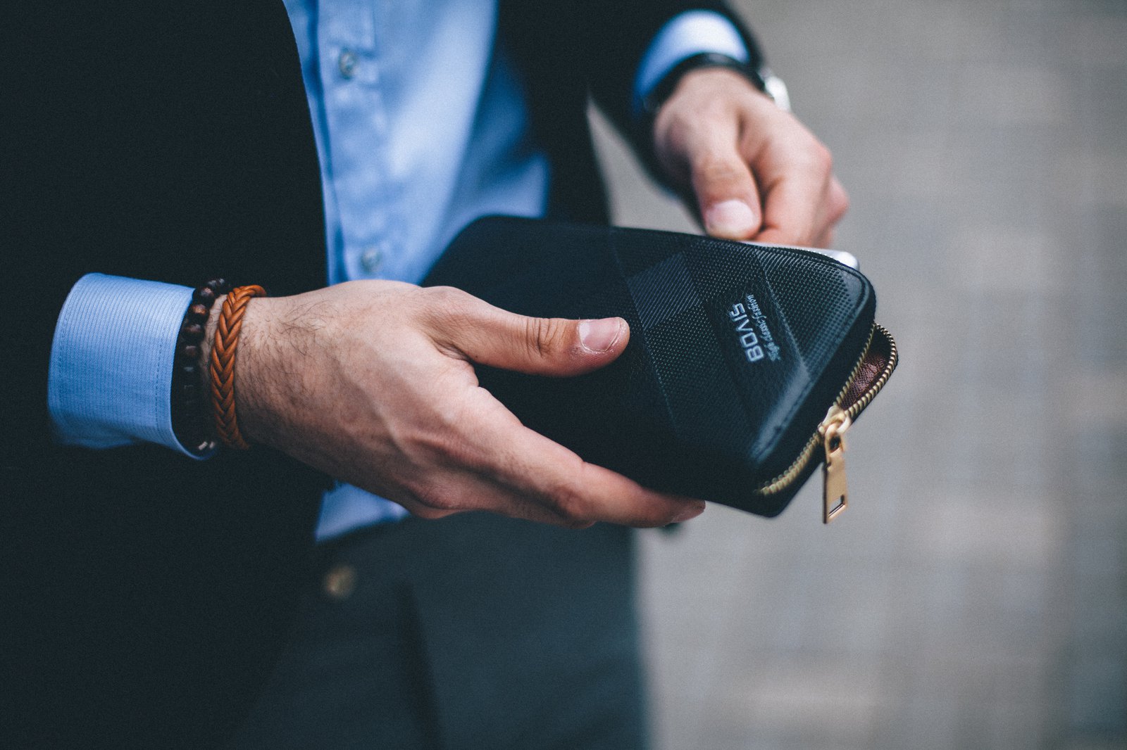 Ein Mann im Anzug verstaut sein Handy, in einer dafür vorgesehenen Tasche.