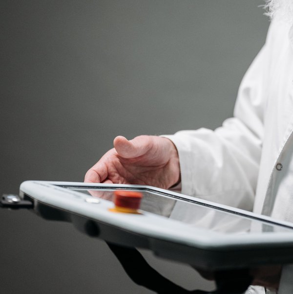 ein Mann im weißen Kittel mit einem Tablet in der Hand