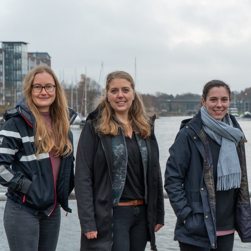 Vier junge Frauen stehen auf einem Steg, im Hintergrund ist Wasser, die Schwentine zu sehen. Von links nach rechts: Helen Alina Pabst, Miriam Maibaum, Lea Schulz und Louise Steinebach.