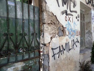 Die Hauswand eines heruntergekommen Gebäudes, auf die "FAMILIA" gesprüht wurde.