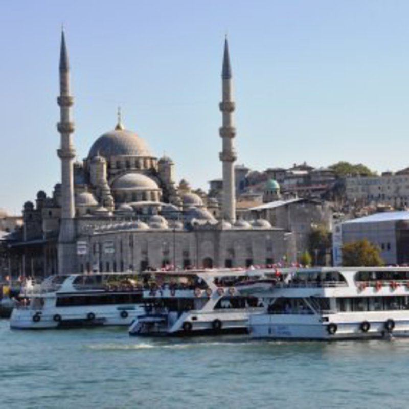 Im Hafen der Stadt liegen in türkis farbenem Wasser, mehrere Schiffe für Rundfahrten an.