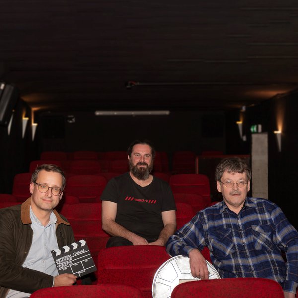 die drei Organisatoren des Bunker-Filmtags sitzen im Kinosaal des Bunker-D