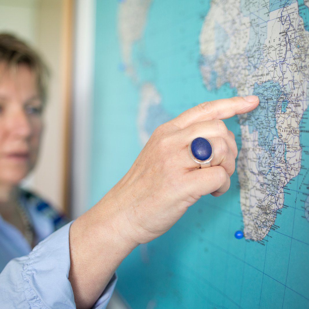 [Translate to English:] Leiterin des International Office zeigt einen Ort auf der Weltkarte