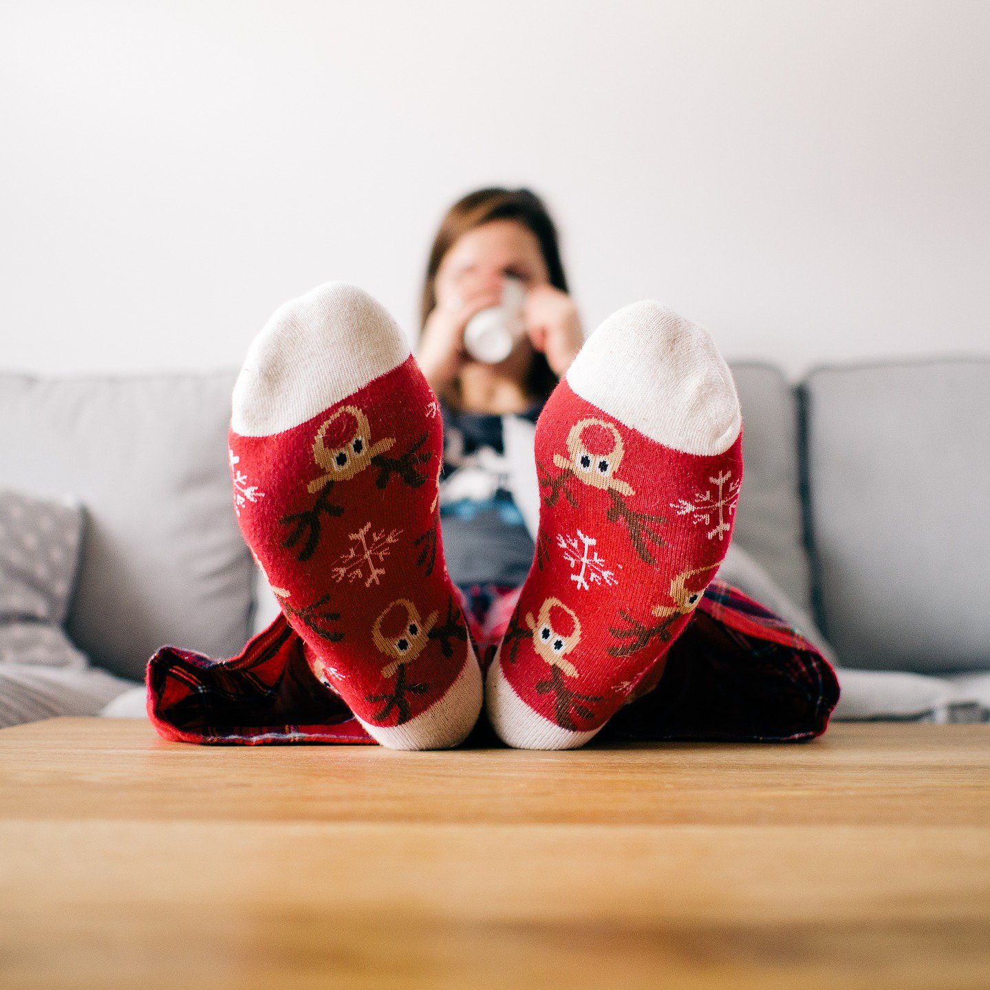 Frau auf Couch mit bunten Weihnachtssocken