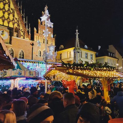 Beleuchtete Fassaden und dekorierte Stände des Weihnachtsmarktes in Lodz