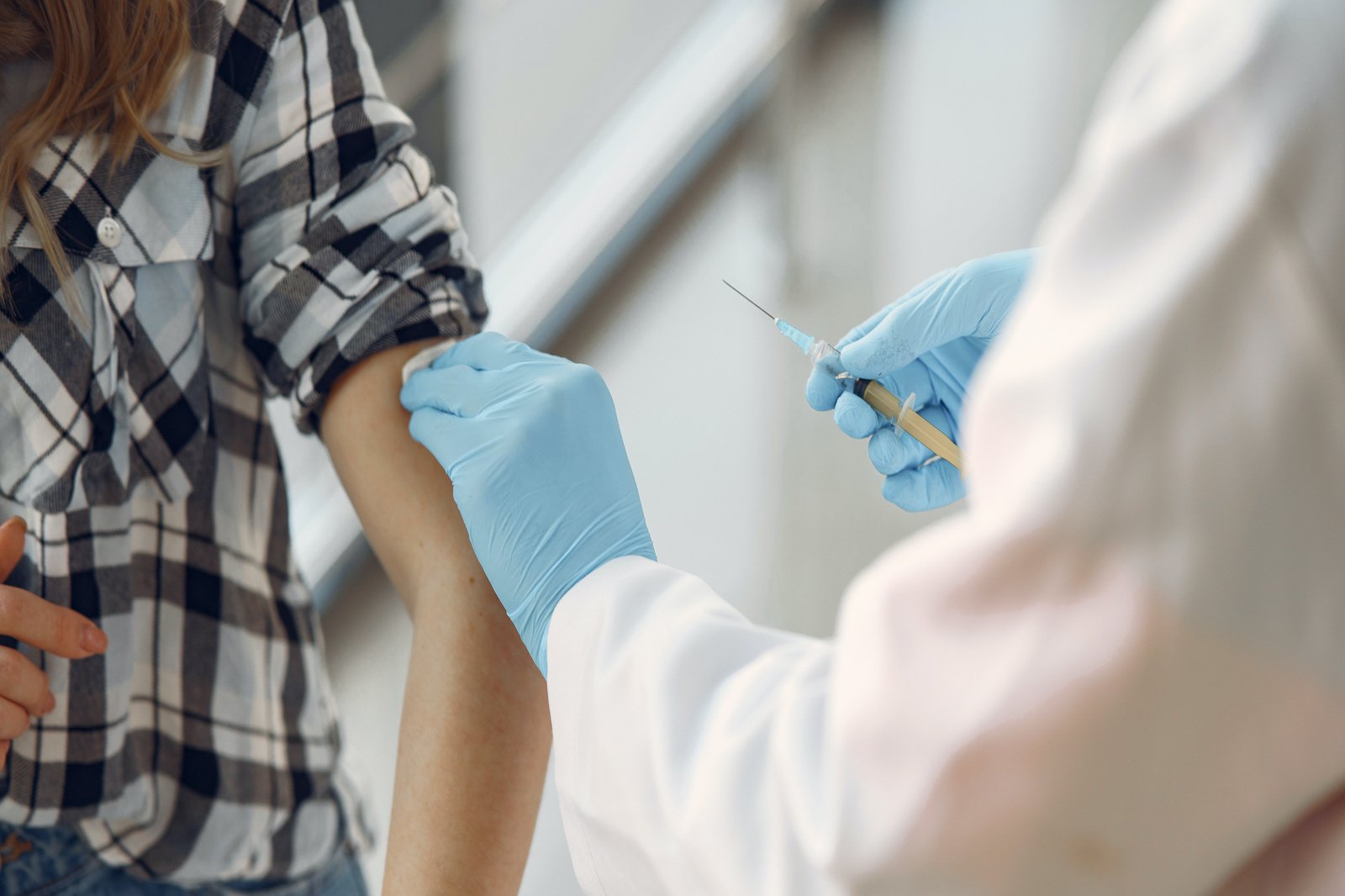 Szene, wo eine Impfspritze an einem Arm angesezt wird.