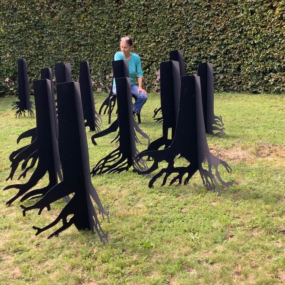 Schwarze Plastiken in Baumform mit Wurzeln