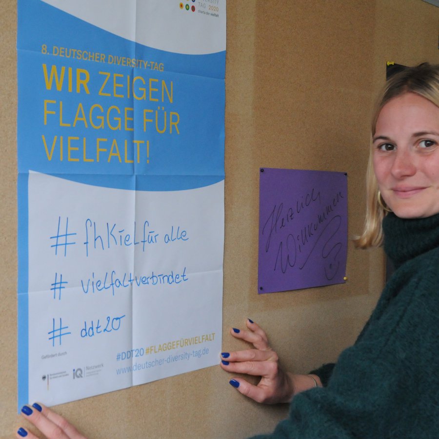 Frau vor Plakat zu #fh Kiel für alle