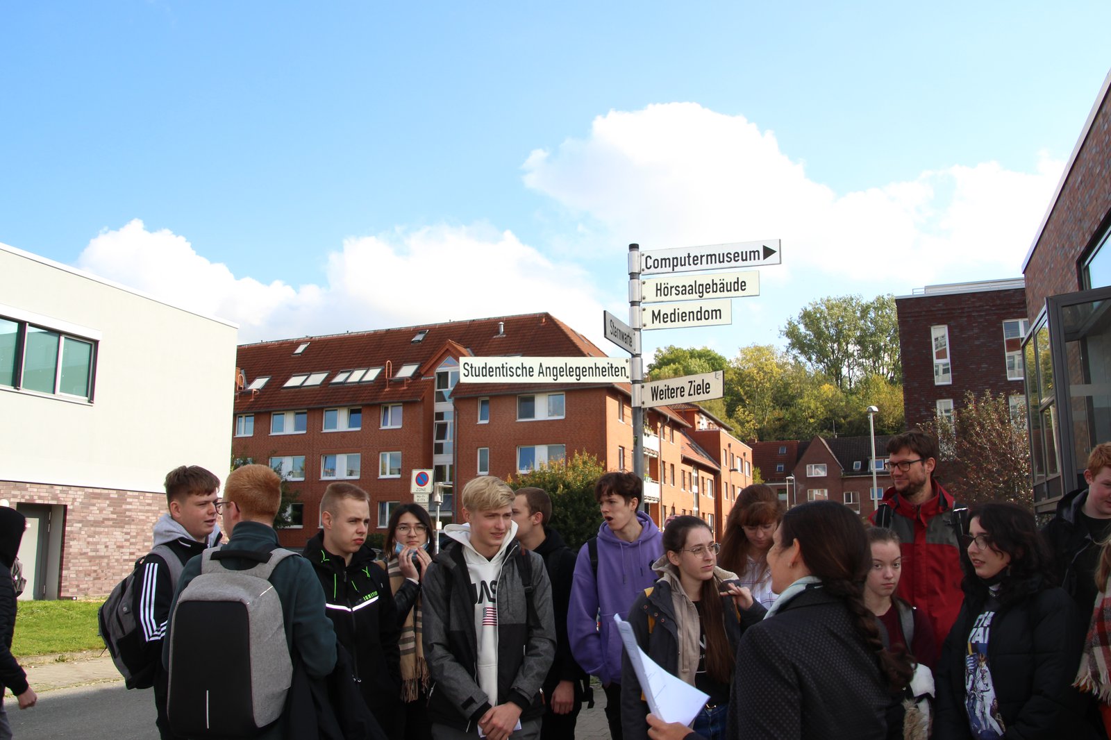 Schülergruppe vor Wegweiser