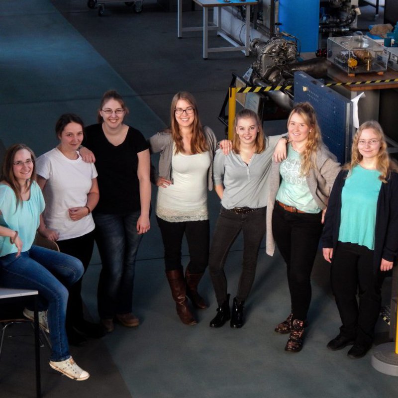 Eine Gruppe Studentinnen posiert in der Halle eines Maschinenraums.