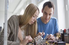 eine Studentin und ein Student an einem Bauteil