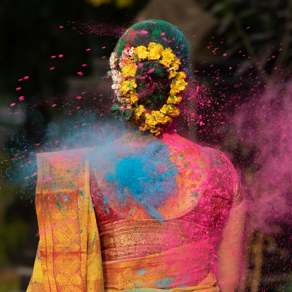 eine Frau in einer Wolke aus Farbpulver beim holy festival