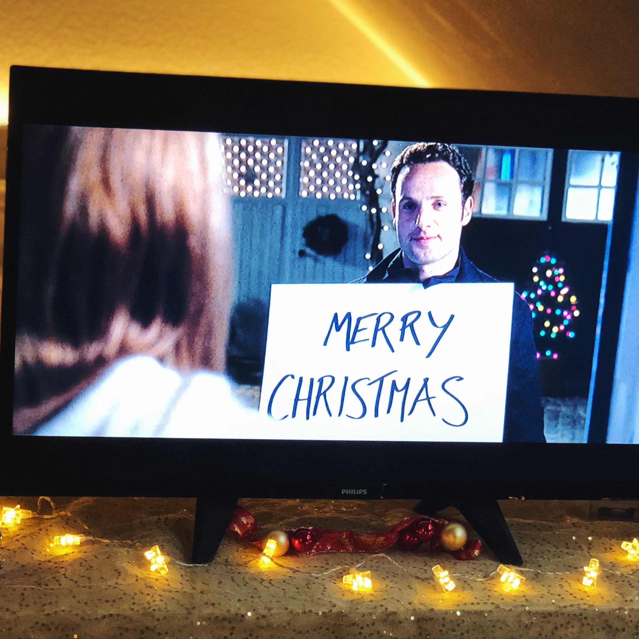 Fernseher, auf dem ein Weihnachtsfilm läuft und Weihnachtsdekoration.